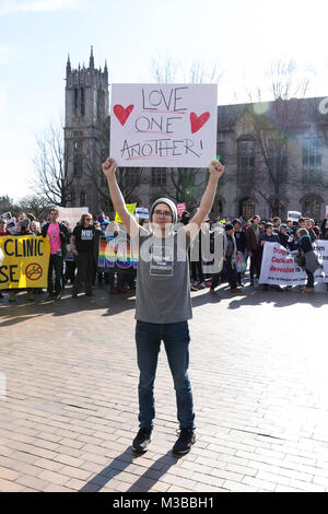 Seattle, Washington, USA. 10 Février, 2018. Un jeune supporter est titulaire d'un signe de protestation comme les étudiants les contre-manifestation de la liberté de la prière patriote Rally entre dans la Place Rouge à l'Université de Washington. L'UW International Socialist Organisation et au moins 12 autres clubs UW a organisé la contre-manifestation, éclipsant la liberté Rally. Fondée par l'activiste Japonais-américain Joey Gibson, le groupe conservateur controversé Patriot Prière plaide en faveur de la liberté d'expression et s'oppose à un gouvernement omniprésent. Le racisme et refuse les connexions Crédit : Paul Christian Gordon/Alamy Live News Banque D'Images