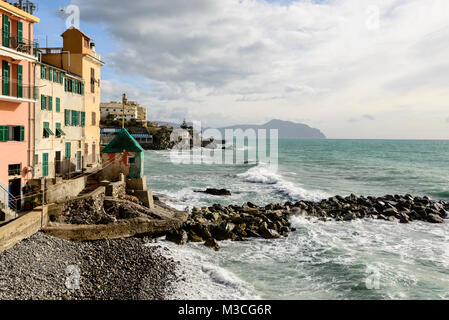 Falaises et littoral de galets avec des maisons traditionnelles avec Portofino cape en arrière-plan, tourné sur une journée d'hiver ensoleillée à Quinto, Genova, Italie Banque D'Images