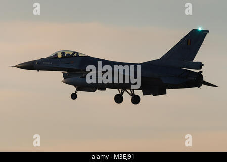 Un avion de chasse F-16 de la Force Aérienne Belge est prêt à atterrir sur la base aérienne de Kleine Brogel en Belgique pendant le coucher du soleil. Banque D'Images