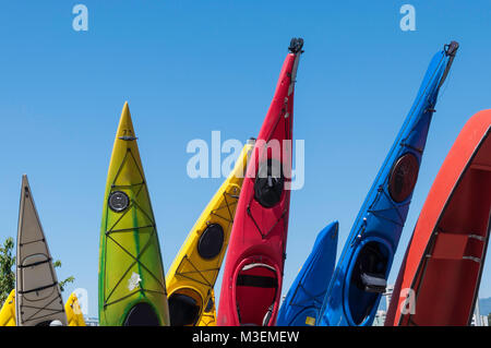 Kayaks colorés stockés sur fin avec fond de ciel bleu Banque D'Images