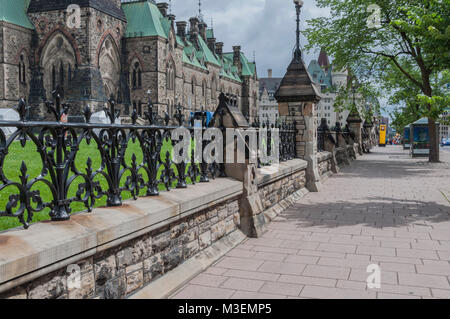 Trottoir en Ottawa, Ontario Canada avec clôture en fer forgé noir au-dessus d'un mur de pierre barrière sur le côté Banque D'Images