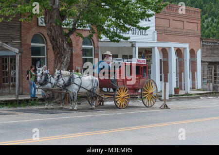 Virginia City, Nevada - Juillet 9, 2010 : les touristes parlent à la conducteur de diligence à poser au sujet de l'embauche d'une diligence pour une balade autour de l'argent ancien Banque D'Images