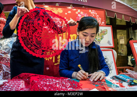 Un maître chinois est engagé dans l'art populaire Jianzhi - folk traditionnel papier découpé chinois décoratif, à Moscou, Russie magasin GUM Banque D'Images
