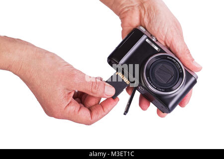 Insérer la carte mémoire dans l'appareil. Mains de femme sur un fond blanc. Banque D'Images