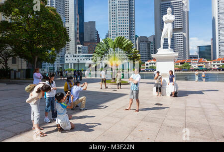 Les touristes de prendre des photos de la statue de Sir Thomas Stamford Raffles à Singapour. La statue se dresse à l'endroit où il a débarqué pour la première fois. Banque D'Images