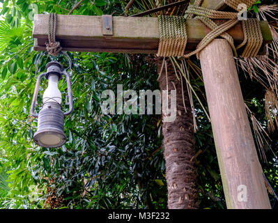 Close-up de lampadaire rustique en bois attachés ensemble avec de la corde. Feuillage en arrière-plan. À Disney Sea, Tokyo. Banque D'Images