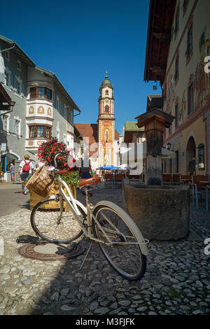 White vintage bicycle avec panier sur Obermarkt rue pavée en pierre dans la vieille ville allemande de Mittenwald Banque D'Images