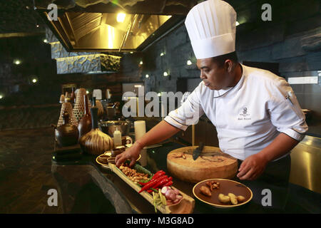 Un chef cuisinier prépare une cuisine indonésienne dans sa cuisine au The Ritz-Carlton Hotel Bali Resort.Nusa Dua. .Bali Indonésie Banque D'Images