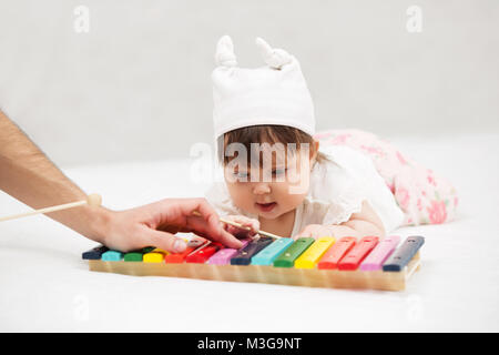 Baby Girl Playing with xylophone jouet sur blanket at home Banque D'Images