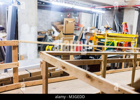 La construction à l'intérieur chambre malpropre industrielle avec les boîtes de carton, rampe en bois, murs de béton, d'un grand nombre d'objets, de fournitures, lors de la rénovation de bureau à ur Banque D'Images