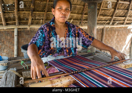 Une femme coud sur un vieux métier à tisser traditionnel dans le village de Rembitan. Au sud de l'île est le cœur de la culture traditionnelle, sesaks spécifi Banque D'Images