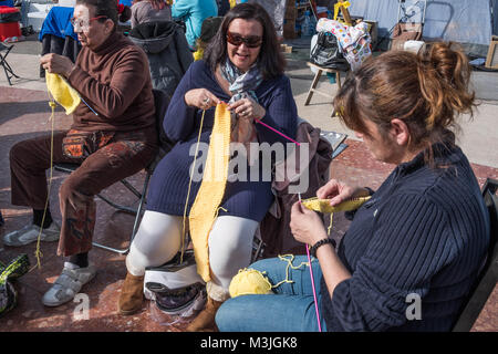 Barcelone, Catalogne, Espagne. Feb 11, 2018. Un groupe de femmes echarpes laine jaune tissé en regard de leurs tentes.Plusieurs tentes occupent la Plaza Catalunya à Barcelone pour réclamer Carles Puigdemont comme président de la Catalogne.Pour les dix jours consécutifs et malgré les menaces d'expulsion par la police d'un petit groupe de partisans de l'indépendance a campé dans le Central Plaza Catalunya à Barcelone. L'initiative veut résister à l'occupation jusqu'à Carles Puigdemont sera reconnaître comme nouveau président de Catalunya à l'encontre de la volonté de le gouvernement de Madrid. (Crédit Image : © Paco Freire/ Banque D'Images