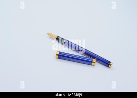 Bleu et un stylo plume avec son couvercle sur fond blanc Banque D'Images