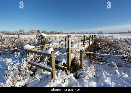 Village de Coddington, Angleterre. Vue pittoresque sur un pont couvert de neige plus stile Coddington Brooke, dans les régions rurales de Cheshire. Banque D'Images