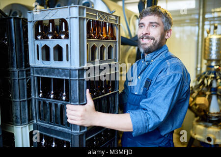 Heureux homme brutal auteur travaillant dans l'entrepôt de la bière Banque D'Images