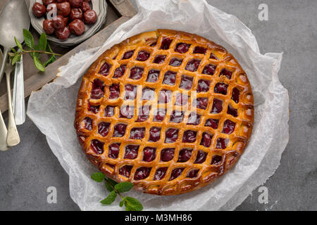 Tarte aux cerises aigres ouvert faits maison, de délicieux desserts sucrés servis sur table gris vue supérieure Banque D'Images