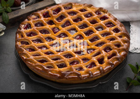 Tarte aux cerises aigres ouvert faits maison, de délicieux desserts sucrés servis sur table gris Banque D'Images