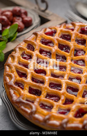 Tarte aux cerises aigres ouvert faits maison, de délicieux desserts sucrés servis sur table gris Banque D'Images