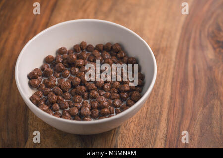 Petit-déjeuner céréales chocolat bol blanc en bois sur le tableau Banque D'Images