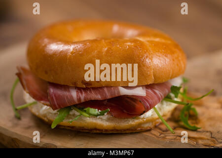 Sandwich bagel de prosciutto et de fromage à la crème sur bois board Banque D'Images