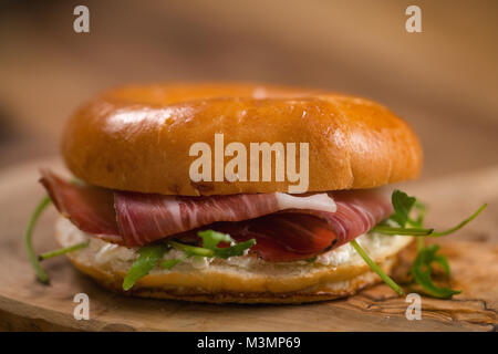 Sandwich bagel de prosciutto et de fromage à la crème sur bois board Banque D'Images