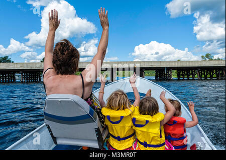 Une grand-mère et ses trois petites-filles faisant la vague dans un bateau en acier Banque D'Images