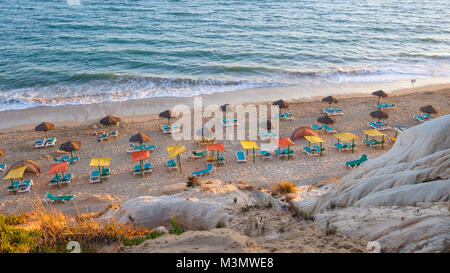 Des chaises longues et des parasols sur la plage de Falesia au soleil de l'après-midi, Algarve, Portugal Banque D'Images