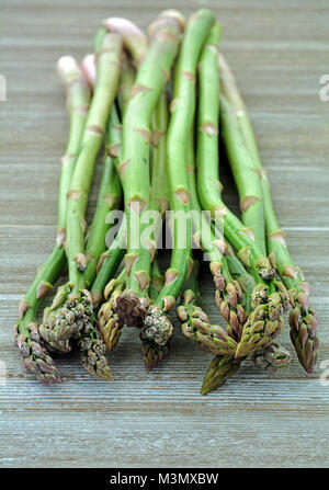 Asperges fraîches cueillies sur fond rustique en format vertical tourné en lumière naturelle Banque D'Images