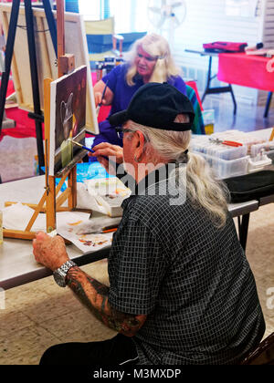 Les aînés ayant vécu une longue vie dure encore rester active s'exprimer en classe de peinture, et l'instructeur Mahto Hogue avec renfort au poignet donne en travaillant sur l'un de leurs tableaux Banque D'Images