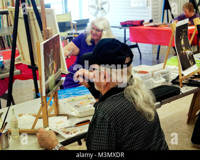 Les aînés ayant vécu une longue vie dure encore rester active s'exprimer en classe de peinture, et l'instructeur Mahto Hogue avec renfort au poignet donne en travaillant sur l'un de leurs tableaux Banque D'Images