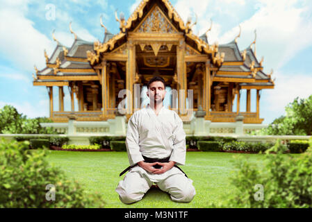 Arts martiaux, karaté traditionnel yoga chasse, monastère sur l'arrière-plan, la ceinture noire Banque D'Images