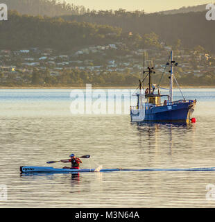 Hobart, Tasmanie, Australie - 28 Février 2014 : pagaie kayak de mer Bateau de pêche passé tôt le matin sur la Derwent Estuary Tasmanie, Australie Banque D'Images