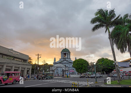 Cathédrale de San Gregorio Magno (St. Grégoire le Grand) dans la ville de Legpazi d'Albay, aux Philippines, définie sur un coucher de soleil et de palmiers. Banque D'Images