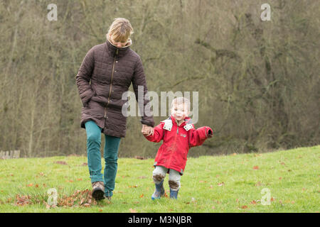 La mère et l'enfant la marche à l'extérieur sur une journée l'hiver. Herefordshire, UK. Banque D'Images