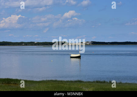 Vue panoramique sur un petit voilier couverts et amarré seul dans les eaux au large de la baie de Cape Cod dans le Massachusetts Banque D'Images