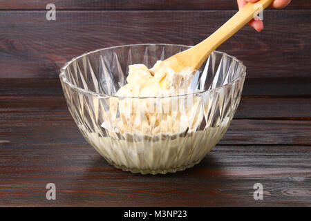 Lame en remuant la main de la pâte à muffins sur une table en bois Banque D'Images