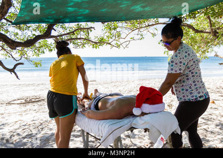 Playa Flamingo, Costa Rica - 25 Décembre : Touristique bénéficiant d'un massage à 4 mains à la plage. 25 décembre 2017, le Costa Rica Playa Flamingo. Banque D'Images