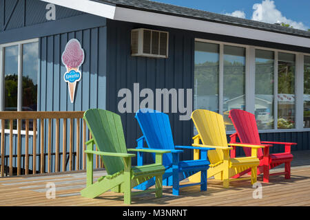 Couleurs primaires lumineuses chaises Adirondack sur pont extérieur magasin concession Georgian Bay park Parry Sound Ontario Canada agréable journée ensoleillée WOP Banque D'Images