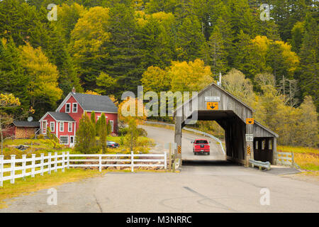 Les arbres d'automne jaune coloré pittoresque vieux pont couvert en bois surround par maison rouge rural St Martins Baie de Fundy, Nouveau-Brunswick Canada Banque D'Images