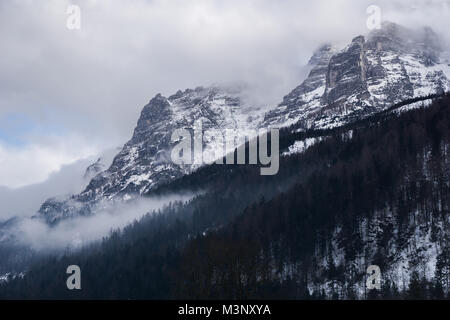 Paysage spectaculaire, mystérieux avec des montagnes enveloppées de brouillard et nuages dans l'hiver. Tourné dans les Alpes autrichiennes près de la ville de Waidring Banque D'Images