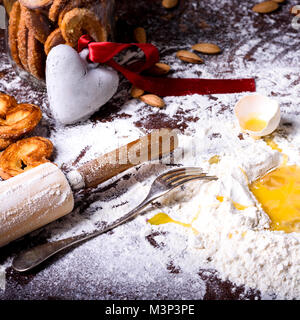 Vue rapprochée de symbole coeur avec ruban rouge et ingrédients pour des biscuits sur la table Banque D'Images