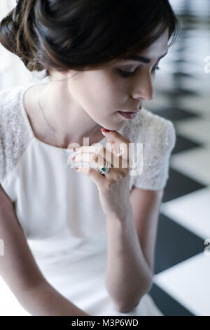 Une belle femme aux cheveux noirs portant une robe de mariage cher monté sur une journée ensoleillée- bien éclairée Banque D'Images