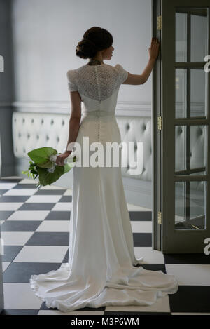 Une belle femme aux cheveux noirs portant une robe de mariage cher monté sur une journée ensoleillée- bien éclairée Banque D'Images