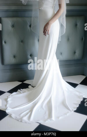 Une belle femme aux cheveux noirs portant une robe de mariage cher monté sur une journée ensoleillée- bien éclairée Banque D'Images