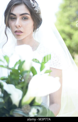 Une belle femme aux cheveux noirs portant une robe de mariage cher monté sur une journée ensoleillée- bien éclairée Banque D'Images