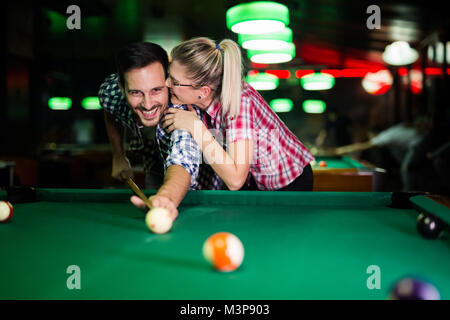 Jeune couple playing snooker ensemble dans bar Banque D'Images