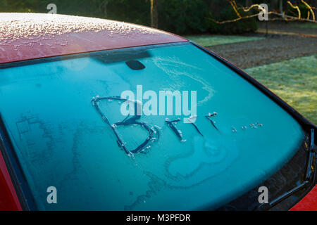 Woking, Surrey, Angleterre du Sud-Est, Royaume-Uni. 12 Février, 2018. Le froid les températures nocturnes forment une couche de givre sur le pare-brise d'une voiture stationnée à l'extérieur pour la nuit par temps froid. Les lettres 'Brrr...' sont écrits dans la glace sur le pare-brise gelé. Credit : Graham Prentice/Alamy Live News Banque D'Images