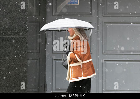 Femme portant un manteau de peau de mouton à Preston, Lancashire.Fév 2018.Météo au Royaume-Uni : froid, humide et enneigé, commencez la journée.Des averses de pluie et de neige ont balayé le nord de l'Angleterre pendant la nuit.Des averses intenses continuent de couvrir la région qui fait des courses dans le centre-ville.Crédit : MediaWorldImages/Alamy Live News Banque D'Images