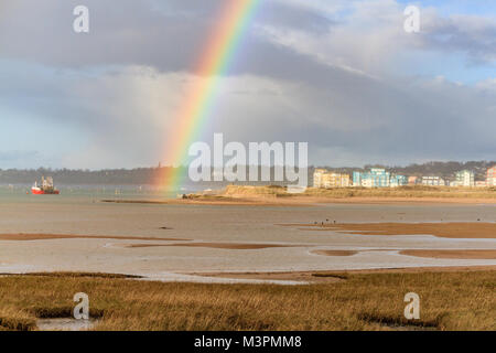 Un arc-en-ciel se forme après une brève douche devant la forte pluie. Vue de Dawlish Warren en regardant l'estuaire de l'exe vers Shelly Road, Exmouth, Devon, Royaume-Uni. Février 2018. Banque D'Images