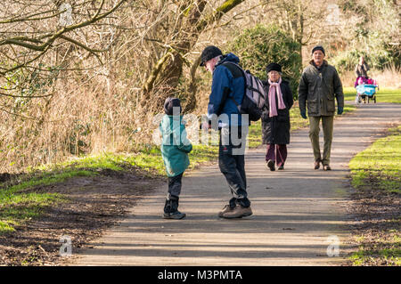 East Lothian, Écosse, Royaume-Uni, 12 février 2017. Un grand-père et son petit-fils de six ans peuvent se promener le long d'un chemin au bord de la rivière Esk, avec un couple plus âgé et une femme qui pousse un buggy double également sur le chemin. Le garçon a une paralysie cérébrale et porte une jambe en fibre de carbone pour une hémiplégie droite Banque D'Images